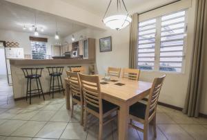a kitchen and dining room with a wooden table and chairs at Villa Bayswater in Tamarin
