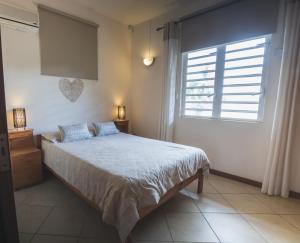 a bedroom with a bed and a window at Villa Bayswater in Tamarin