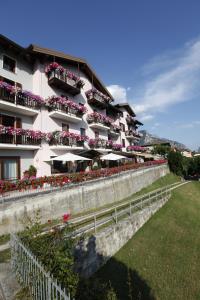 - un bâtiment avec des balcons fleuris et des parasols dans l'établissement Hotel Spera, à Strigno