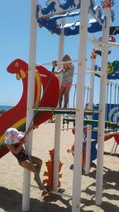 two children playing on a playground at the beach at Fresa Apartaments in La Mata
