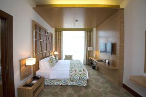 a hotel room with a bed and a television at Best Western Plus Pearl Creek in Dubai