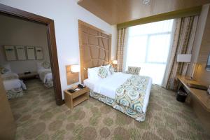 a hotel room with a bed and a large window at Best Western Plus Pearl Creek in Dubai