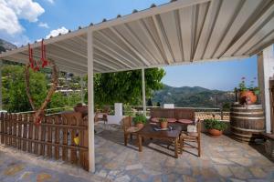 un patio con toldo, mesa y sillas en Manthiata Studios, en Exanthia