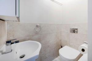 a bathroom with a white toilet and a sink at Prime London Apartment, Oxford Circus in London