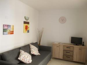 a living room with a couch and a tv on a cabinet at Caleta Paraiso - Lovely Coastal Apartment in Costa de Antigua