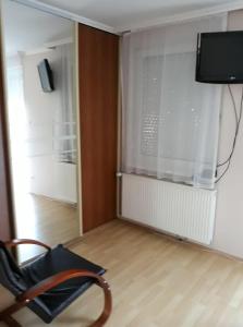 ハイドゥソボスローにあるKiskuckó Apartmanの壁にテレビと椅子が備わる客室です。 +3枚の写真