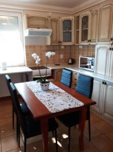 cocina con mesa de madera y sillas azules en Kiskuckó Apartman en Hajdúszoboszló