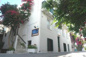 um edifício branco com flores em frente em Syrianos Hotel em Naxos Chora