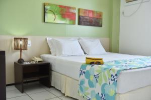 um quarto de hotel com uma cama com uma bolsa amarela em Hotel - Gran Lençóis Flat em Barreirinhas