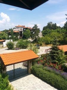 a garden with an orange roof and a gate with flowers at Limani Guest house in Sozopol