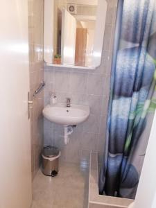 a bathroom with a sink and a shower curtain at Rooms Radic in Dubrovnik