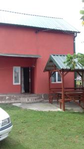 a red building with a picnic table in front of it at Natali & Giga in Ureki