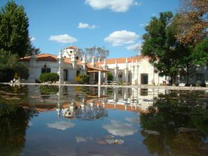 un edificio con reflejo en una piscina de agua en Hotel Savoia Mendoza en Guaymallén