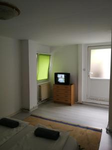 uma sala de estar vazia com uma televisão e uma janela em Reben Haus em Sibiu