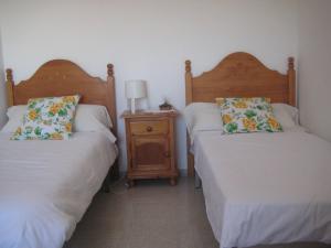 サンルーカル・デ・バラメダにあるCasa Algaidaのベッドルーム1室(ベッド2台、ナイトスタンド付)