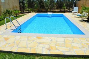 a swimming pool in a yard with a stone floor at Petrus Vacanze in Camisa