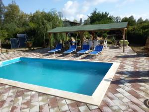 a swimming pool with chairs and a gazebo at Villa Angioj in Tottubella