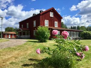 a red barn with pink flowers in front of it at THE LODGE Torsby in Torsby