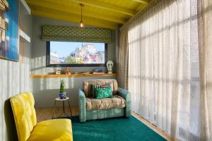 a living room with a chair and a window at The Frogs_Guest House in Athens