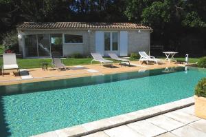 a swimming pool with chairs and a house at un lit en provence in Éguilles