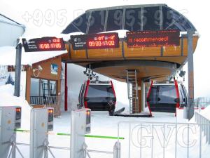 古道里的住宿－GVC 210 New Gudauri Mountain View，雪地里停有两辆车的滑雪缆车