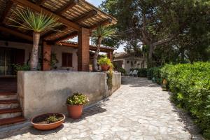 a patio with potted plants and a house at Sogno Siciliano Turismo Rurale in Erice