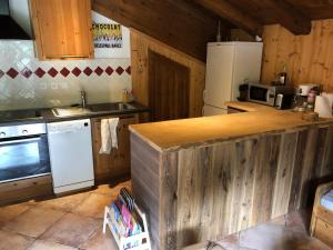 una cucina con piano di lavoro in legno e frigorifero di Appartement Du Dou Des Ponts a Pralognan-la-Vanoise