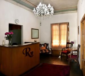 a living room with a table and a chandelier at Hoteles Riviera Colonial in Arequipa