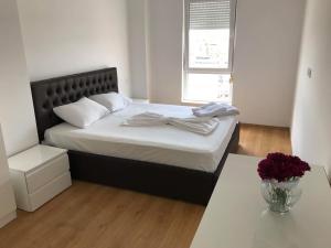 um quarto com uma cama com uma mesa e uma janela em Cassiopeia Apartament em Tirana