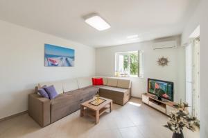 a living room with a couch and a tv at FEWO Villa Adria in Barušić