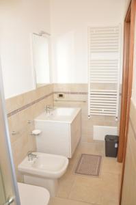 a bathroom with a white toilet and a sink at Monolocale Garden in Taviano +30 photos