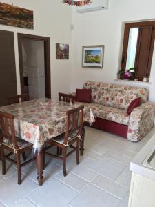 uma sala de estar com uma mesa e um sofá em Villa Trullo Cristi em Alberobello