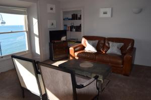 a living room with a couch and a table at Awel Mor Holiday Apartment in Aberystwyth +23 photos