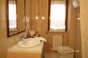 a bathroom with a sink and a toilet at Antonhouse Alghero in Alghero