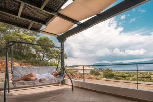 PefkaliにあるSea view Amoni villaの海を見下ろすバルコニーのソファに寝る男