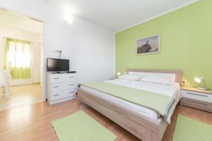um quarto com uma cama grande e uma televisão em Apartments Maria em Vodice