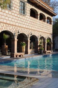 a building with a swimming pool in front of it at Hotel Ex Hacienda La Pitaya Querétaro in Villa del Pueblito