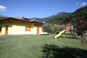 un patio con un tobogán y un parque infantil en La Giostra Home Apartments, en Drena