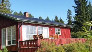 ein rotes Haus mit Stühlen auf einer Terrasse in der Unterkunft Amazing Sea View Luleå in Luleå