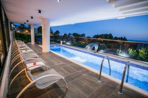 a hotel swimming pool with a view of the ocean at Villa Delux in Ulcinj