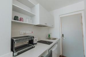 a small kitchen with white cabinets and a sink at River View Boutique Apts in Ayia Napa