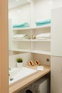 a bathroom with a sink and a washing machine at Studio Morski Klimat in Władysławowo