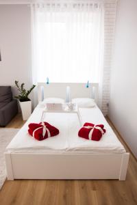 a bedroom with a white bed with red pillows on it at Studio Morski Klimat in Władysławowo +20 photos