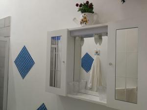 a white bathroom with a mirror and a sink at A due passi dal mare in Fontane Bianche