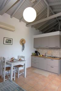 a kitchen with a white table and a white table and chairs at Kripia Holiday Villas in Kardamyli +44 photos