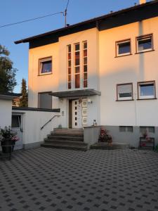 a large white house with a courtyard at Denkys-Ferienwohnung in Maulburg