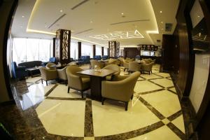 un restaurante con sillas y mesas en el vestíbulo en SAS Al Olaya Hotel Suites, en Al Khobar