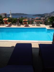 einen Pool mit Stühlen und Blick auf das Wasser in der Unterkunft Apartments Villa Čučuk in Budva