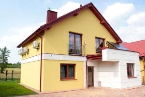żółto-biały dom z czerwonym dachem w obiekcie Apartamenty SaltApart2 w Wieliczce