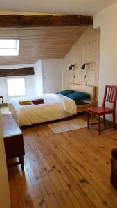 1 dormitorio con 1 cama grande y 1 silla roja en Le Velo Rouge, en Le Puy en Velay